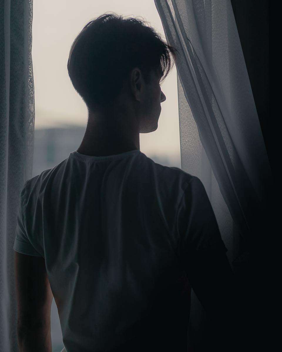 portrait of zaccy shilhouette looking out window